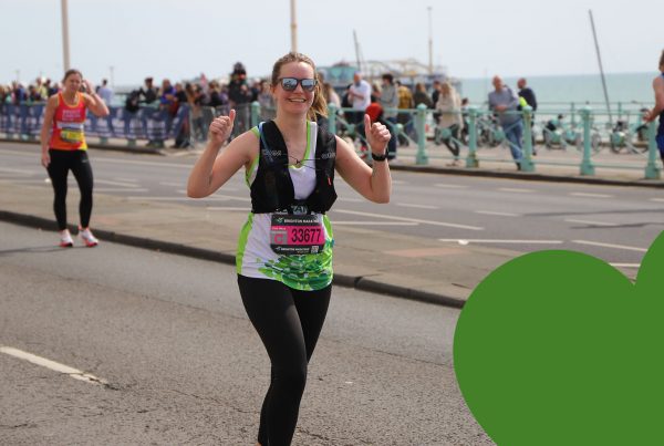 Smiling St Peter & St James Hospice runner with green heart overlaid